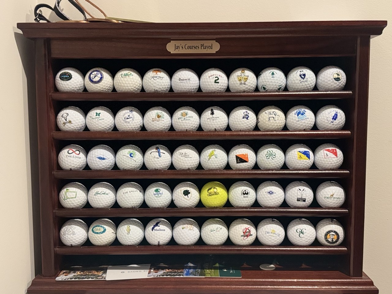 The Ball Wall — 50 golf balls ranked on a wooden rack